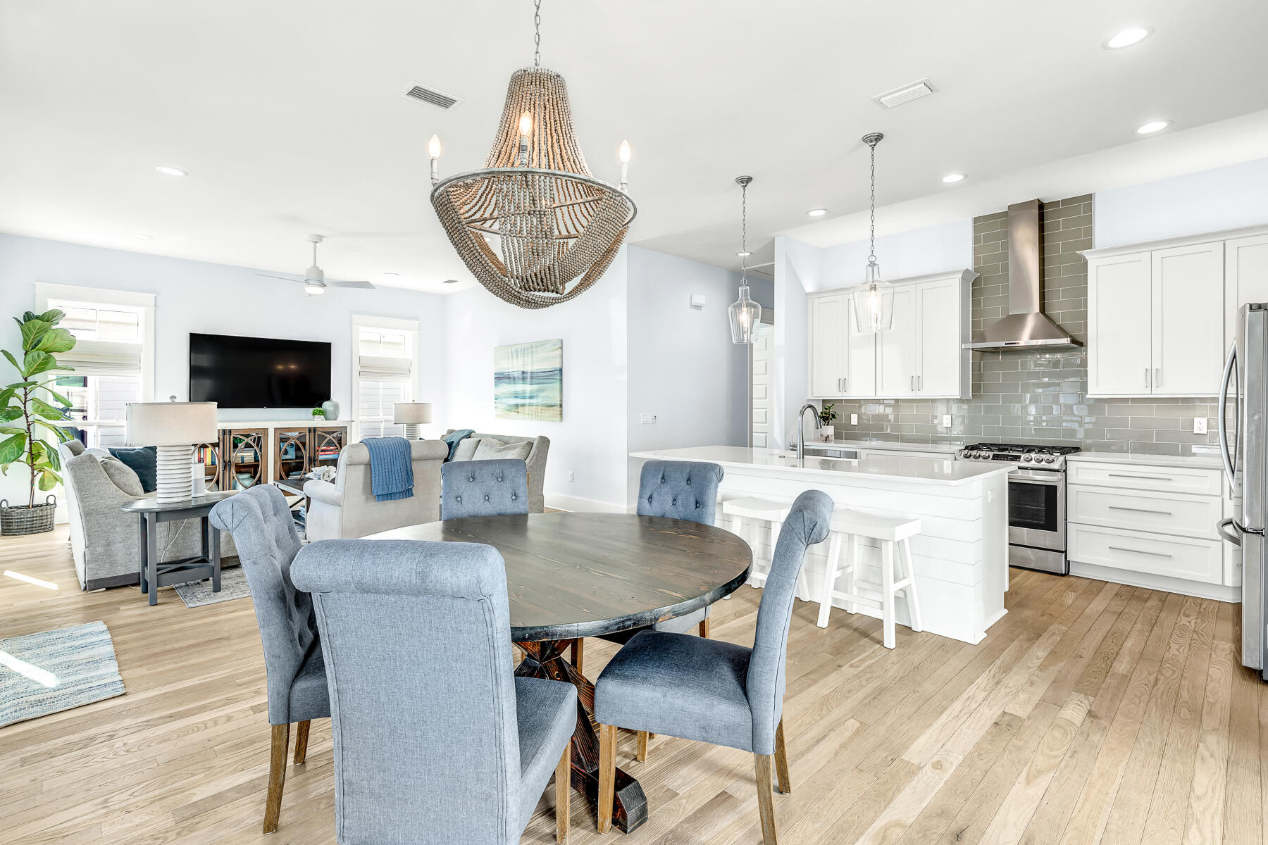 56 Cypress Drive Santa Rosa Beach, FL 32459 - Photo 3 of 61 an open kitchen with granite countertop a stove a sink a dining table and chairs with wooden floor