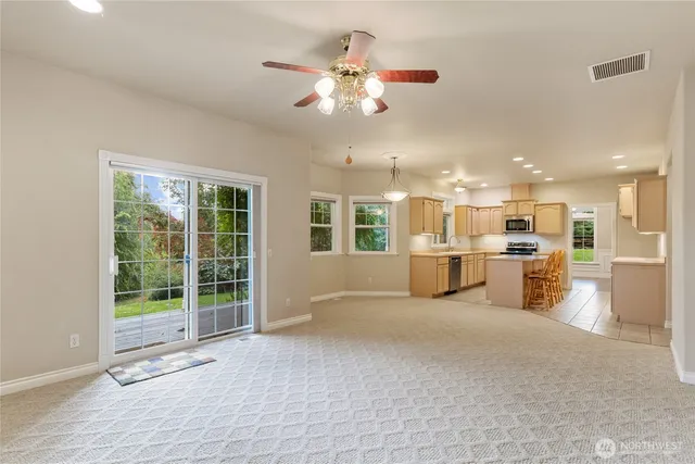 a view of a livingroom with furniture a ceiling fan and window