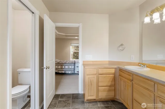 a en suite bathroom with a granite countertop sink and a mirror
