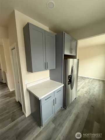 a kitchen that has a fridge and wooden floor