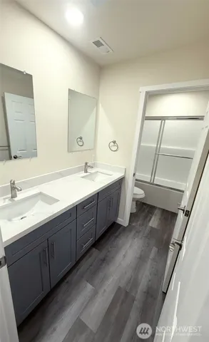a spacious bathroom with a double vanity sink and mirror