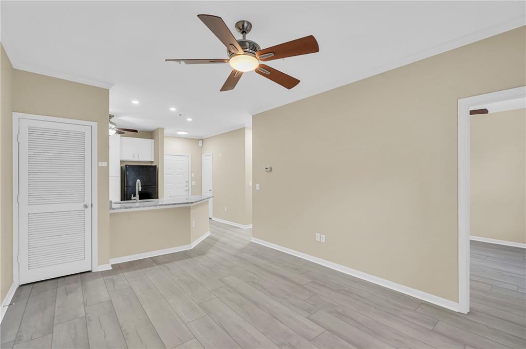 821 Ralph McGill Boulevard Northeast, Unit 3325 Atlanta, GA 30306 - Photo 18 of 54 a view of a livingroom with a kitchen space with wooden floor a ceiling fan and a window