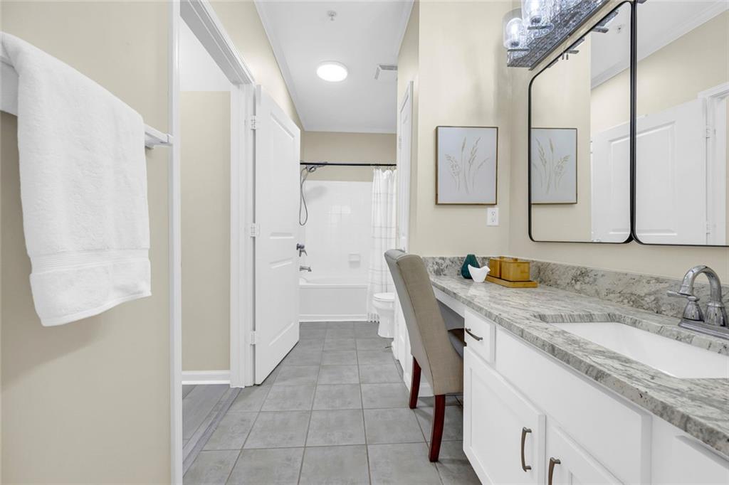 821 Ralph McGill Boulevard Northeast, Unit 3325 Atlanta, GA 30306 - Photo 26 of 54 a bathroom with a granite countertop sink a mirror and a shower