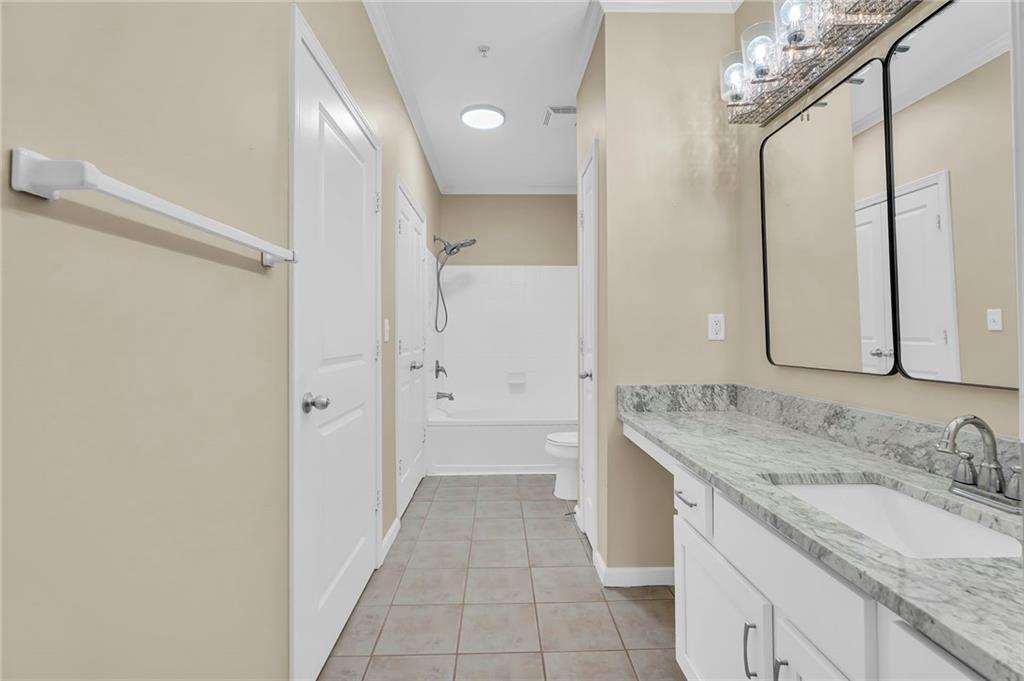 821 Ralph McGill Boulevard Northeast, Unit 3325 Atlanta, GA 30306 - Photo 27 of 54 a bathroom with a granite countertop sink a mirror and a bathtub