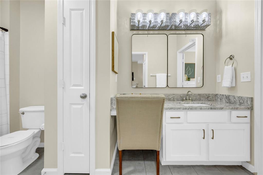 821 Ralph McGill Boulevard Northeast, Unit 3325 Atlanta, GA 30306 - Photo 28 of 54 a bathroom with a granite countertop sink a toilet and a mirror