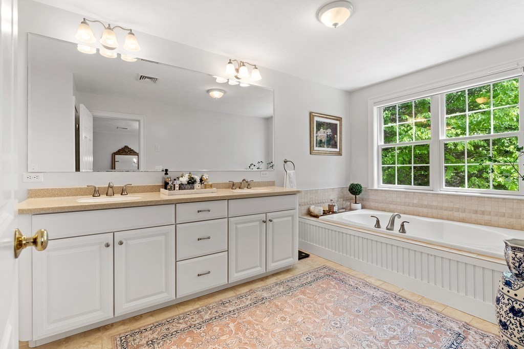 19 Village Road Pepperell, MA 01463 - Photo 19 of 41 a spacious bathroom with a tub a double sink and a window