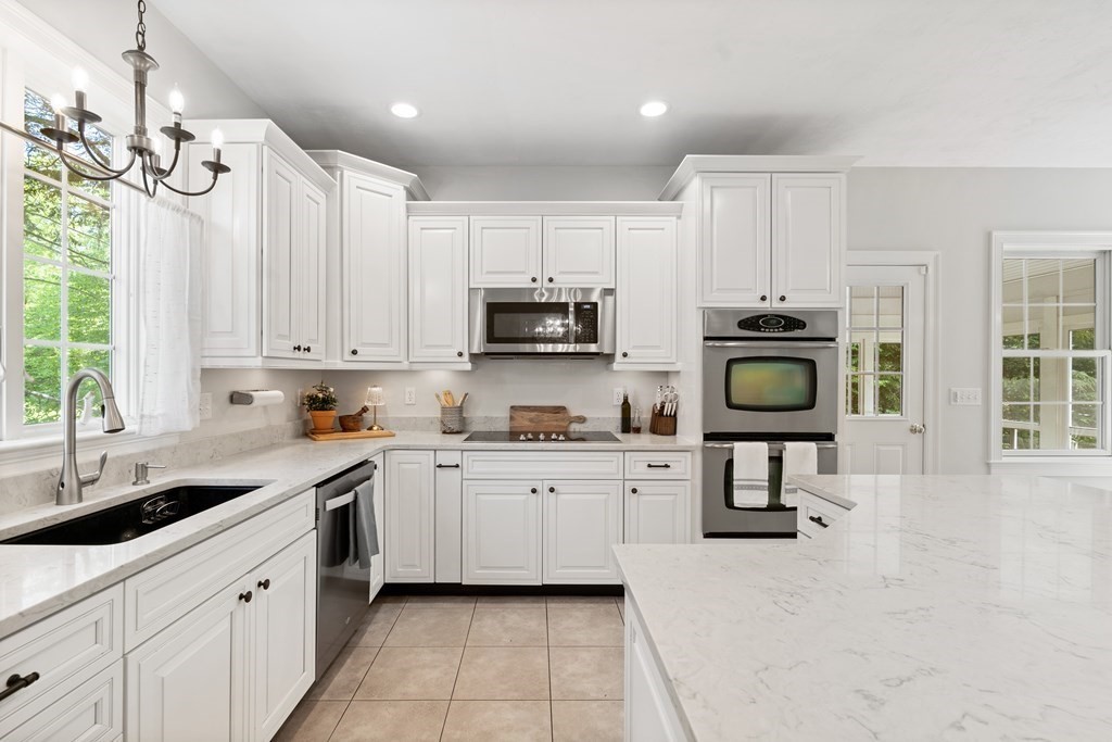 19 Village Road Pepperell, MA 01463 - Photo 2 of 41 a kitchen with stainless steel appliances a stove a sink a microwave a refrigerator and cabinets