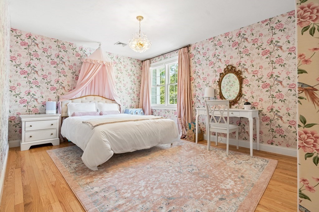 19 Village Road Pepperell, MA 01463 - Photo 24 of 41 a bedroom with a bed and a chandelier