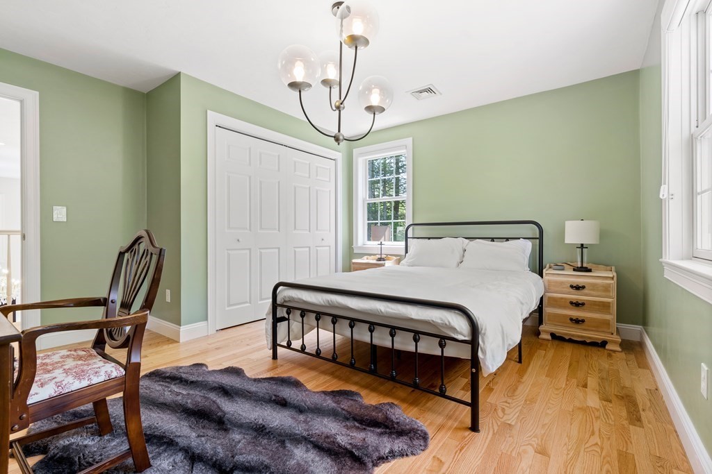 19 Village Road Pepperell, MA 01463 - Photo 25 of 41 a bedroom with a bed a chair and a chandelier