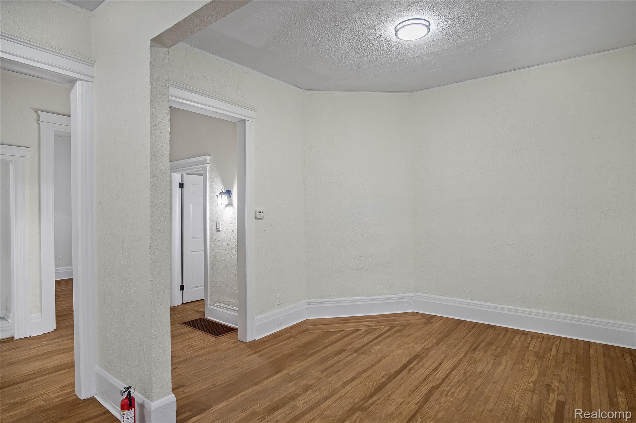 427 Melbourne Street Detroit, MI 48202 - Photo 4 of 29 Unfurnished room featuring a textured ceiling and wood finished floors