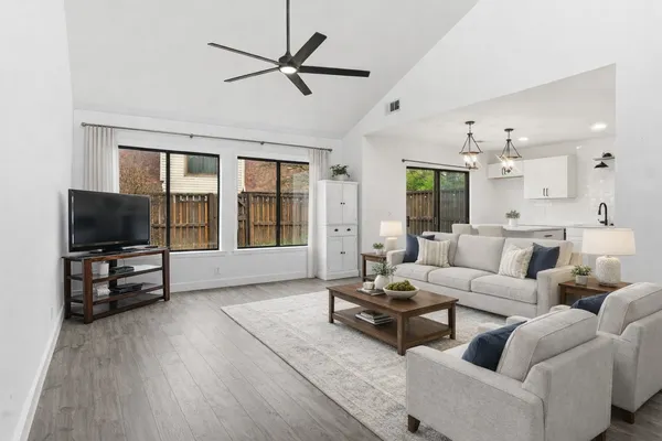 a living room with furniture a flat screen tv and a large window