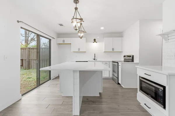 a kitchen with a sink stainless steel appliances cabinets and a counter top space