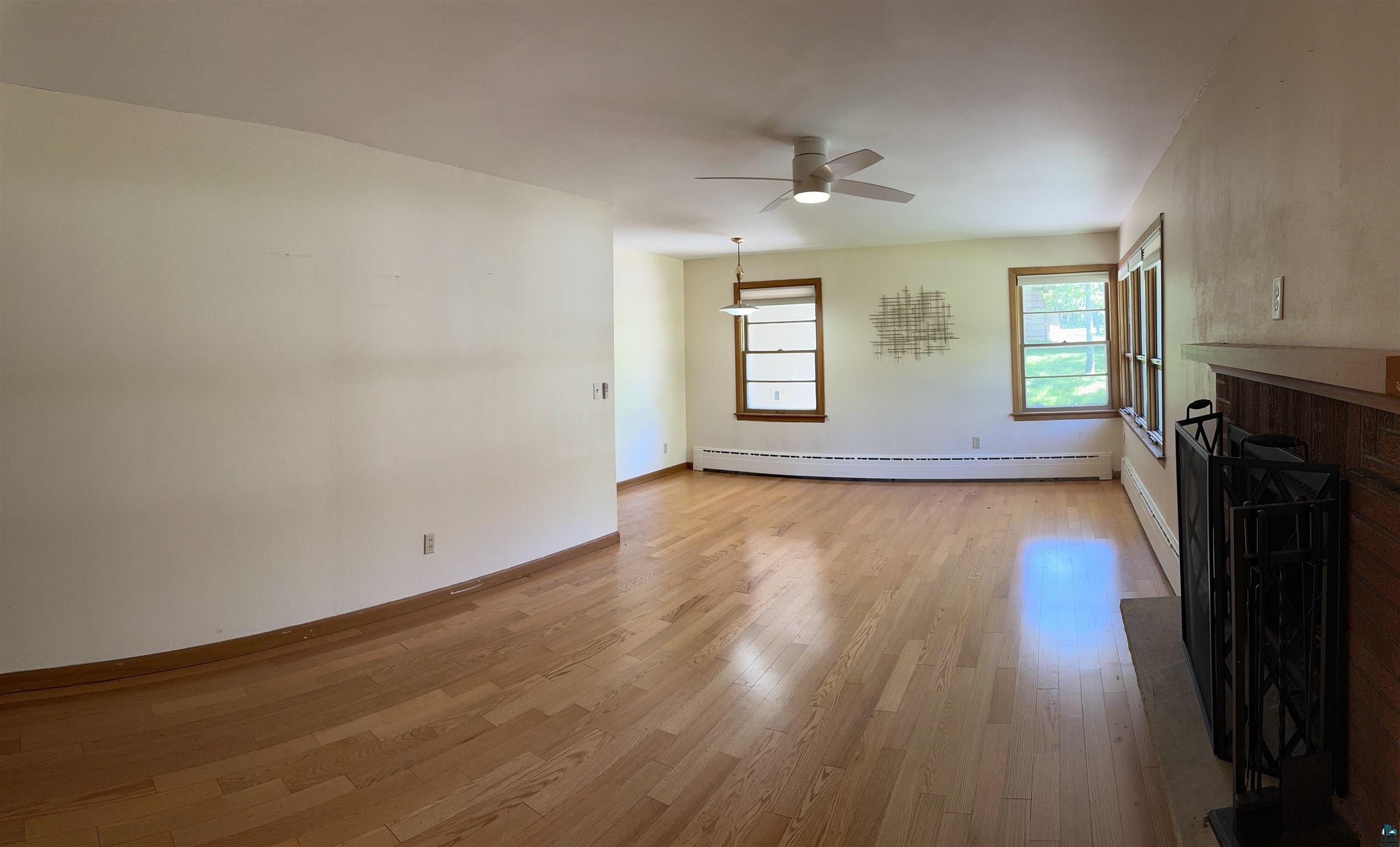 2309 Anderson Road Duluth, MN 55811 - Photo 8 of 36 Unfurnished living room featuring a baseboard heating unit, ceiling fan, and hardwood / wood-style flooring