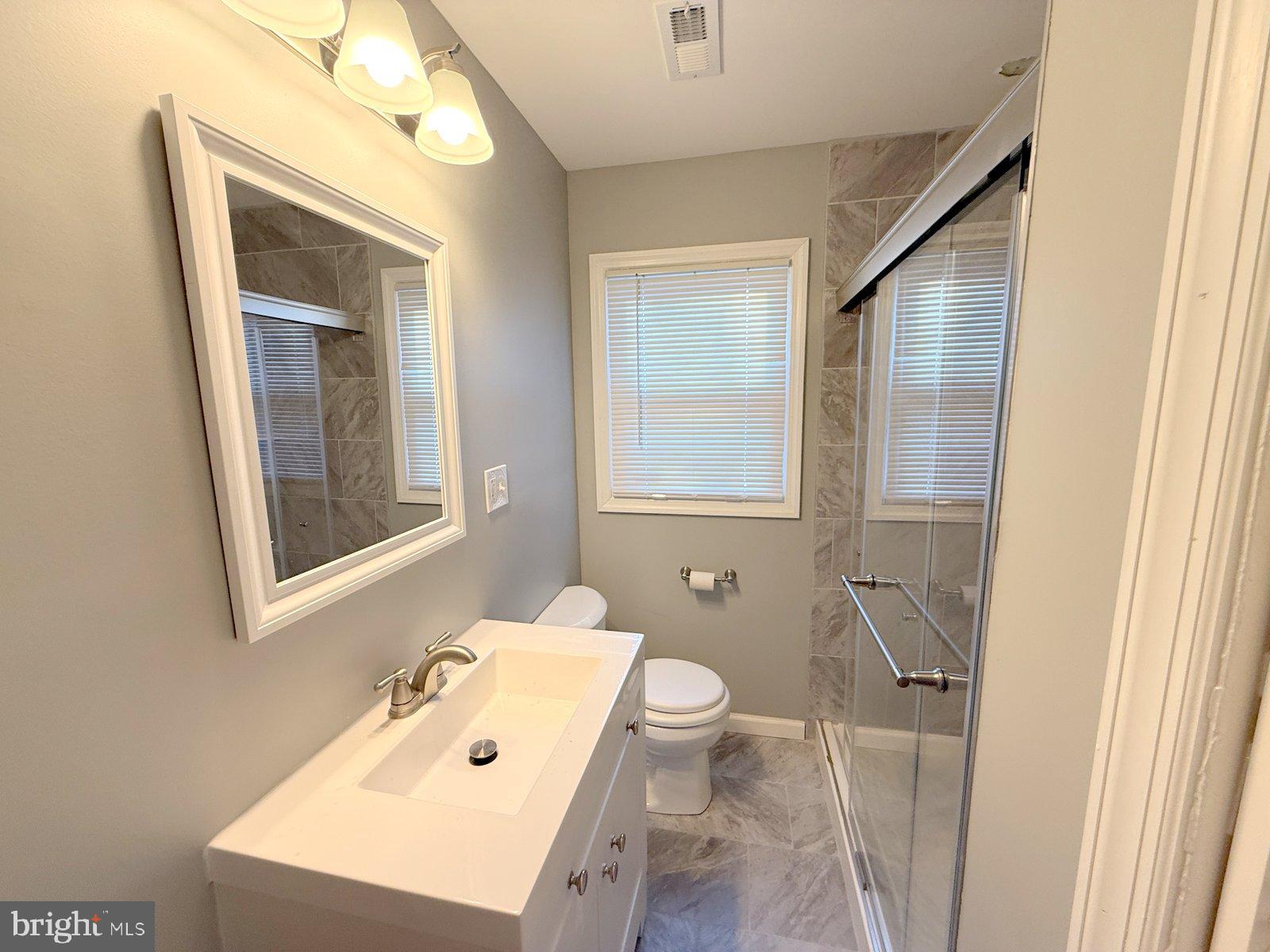 12 Wesley Avenue Cherry Hill, NJ 08002 - Photo 12 of 24 a bathroom with a sink a toilet a mirror and vanity