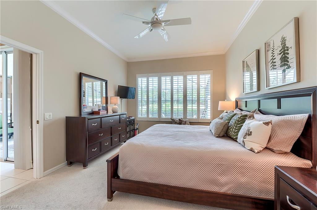 9296 Spring Run Boulevard Estero, FL 34135 - Photo 15 of 38 a bedroom with a large bed and a chandelier