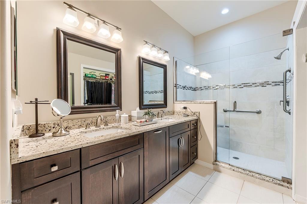 9296 Spring Run Boulevard Estero, FL 34135 - Photo 16 of 38 a bathroom with a double vanity sink mirror and shower