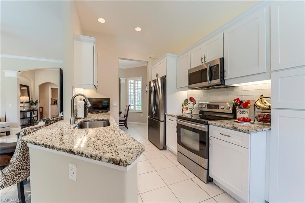 9296 Spring Run Boulevard Estero, FL 34135 - Photo 8 of 38 a kitchen with stainless steel appliances granite countertop a sink stove oven and refrigerator