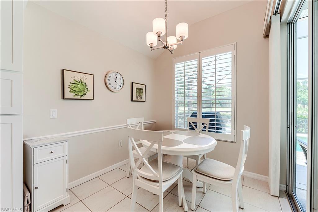 9296 Spring Run Boulevard Estero, FL 34135 - Photo 10 of 38 a dining room with chandelier and wooden floor