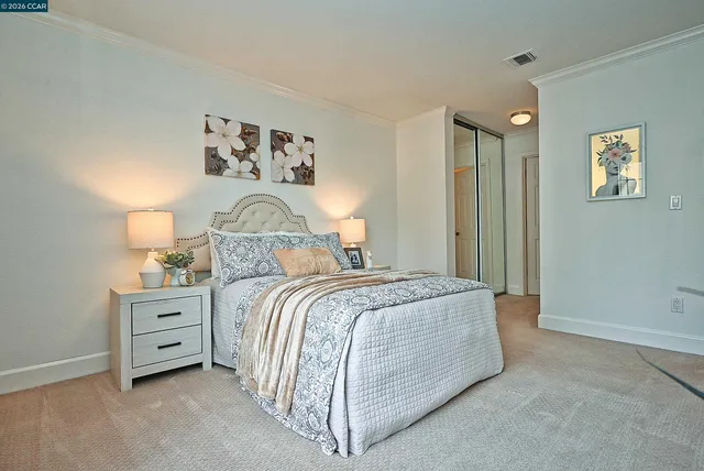 a bedroom with a bed and a lamp on the dresser