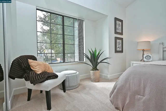 a spacious bedroom with furniture and a window