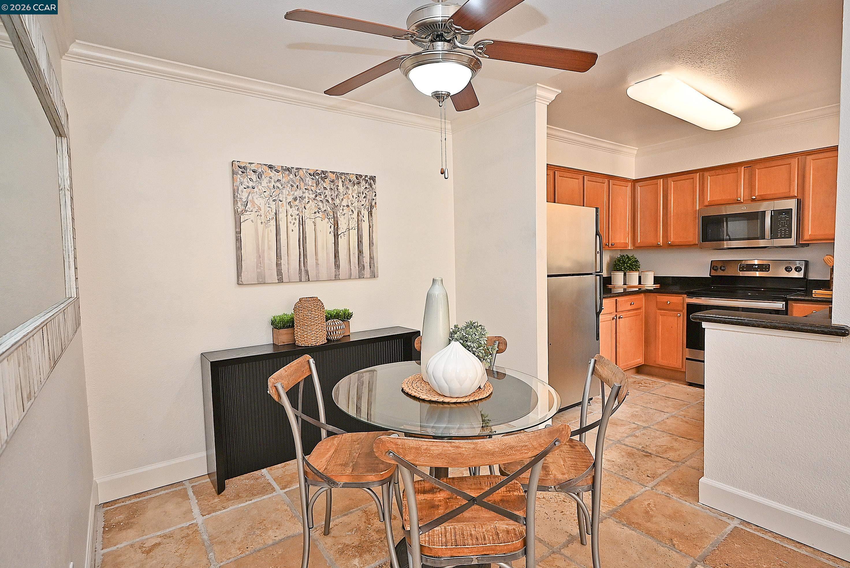 182 Eastridge Drive San Ramon, CA 94582 - Photo 9 of 47 a kitchen with stainless steel appliances kitchen island granite countertop a dining table chairs and a refrigerator