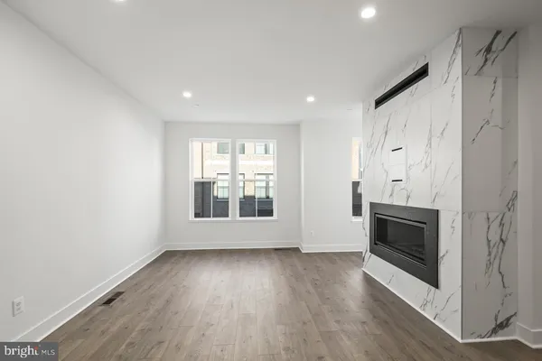 a view of wooden floor fire place and windows in a room