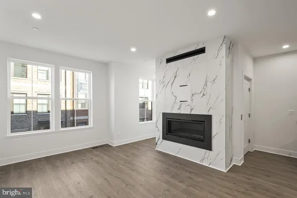 a view of empty room with wooden floor and fireplace