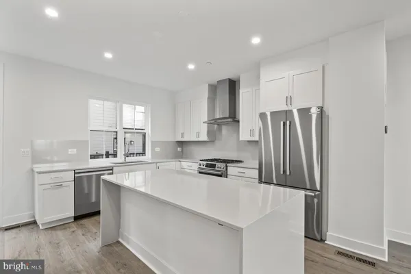 a kitchen with kitchen island sink stove and refrigerator