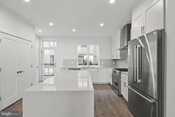 a kitchen with stainless steel appliances a refrigerator and a stove top oven