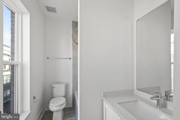a view of an empty room with wooden floor and closet