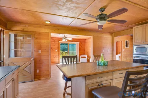 a kitchen with stainless steel appliances granite countertop a refrigerator a sink dishwasher a stove and a dining table with wooden floor