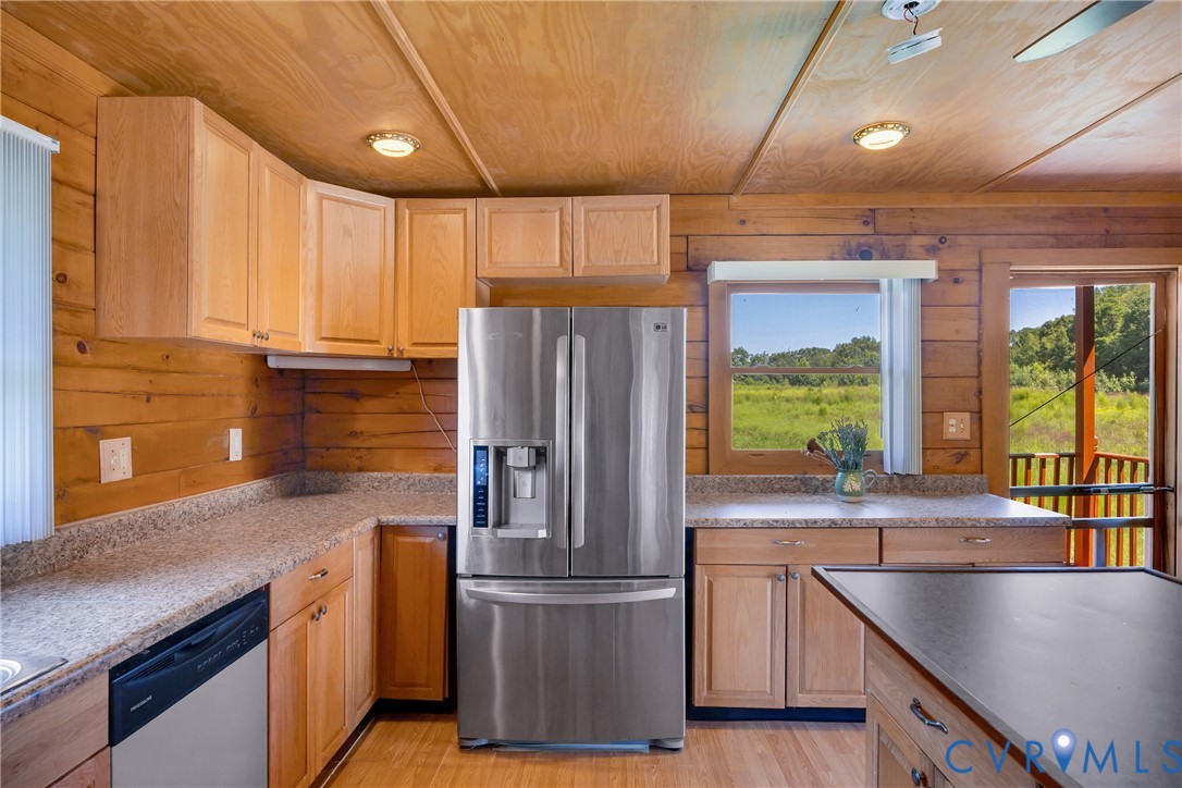 3000 Mineral Springs Road Boydton, VA 23917 - Photo 13 of 42 a kitchen with stainless steel appliances granite countertop a refrigerator a sink dishwasher a stove and a dining table with wooden floor