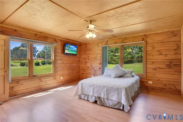 a view of a livingroom with a chandelier fan and wooden floor