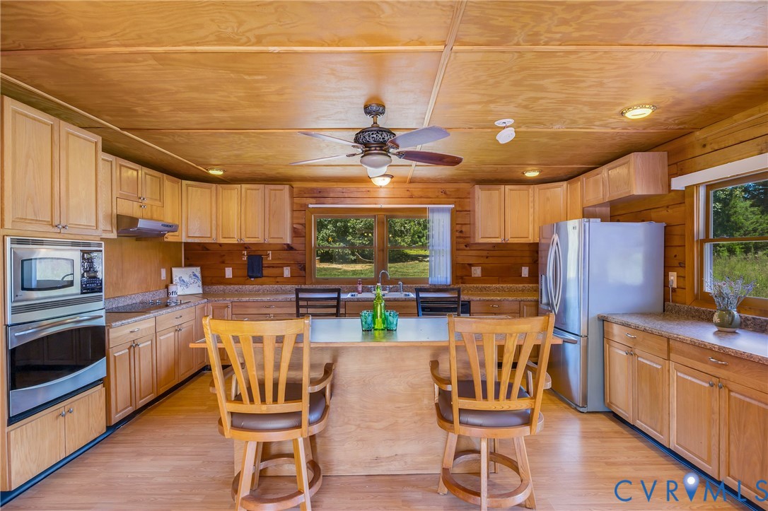 3000 Mineral Springs Road Boydton, VA 23917 - Photo 9 of 42 a kitchen with stainless steel appliances kitchen island granite countertop a table chairs in it and a wooden floors