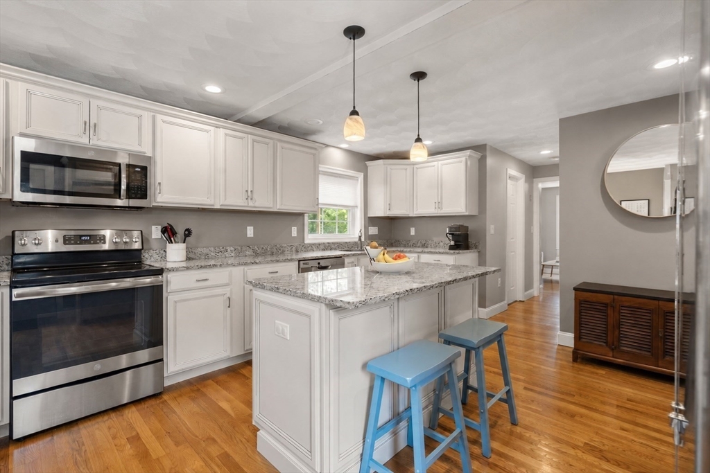 46 MacArthur Road Stoneham, MA 02180 - Photo 2 of 41 a kitchen with stainless steel appliances granite countertop a stove a sink a microwave a refrigerator and cabinets