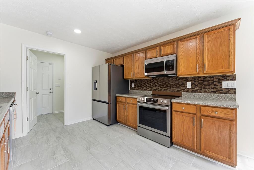 1500 Keystone Drive Conley, GA 30288 - Photo 11 of 25 a kitchen with stainless steel appliances granite countertop a stove a sink and a microwave