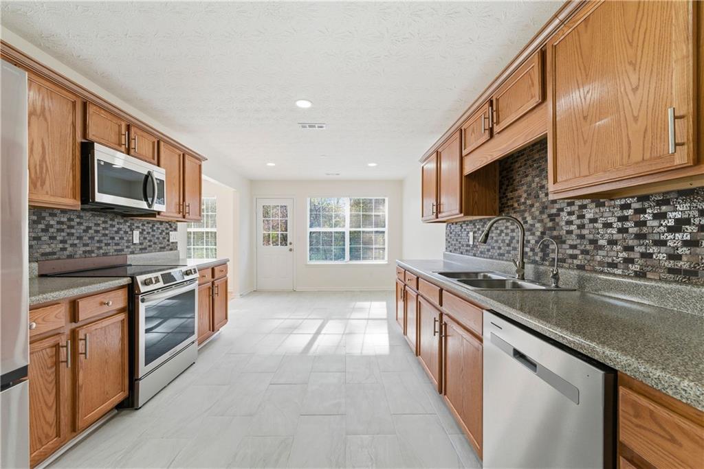 1500 Keystone Drive Conley, GA 30288 - Photo 12 of 25 a large kitchen with stainless steel appliances granite countertop a sink stove microwave and refrigerator