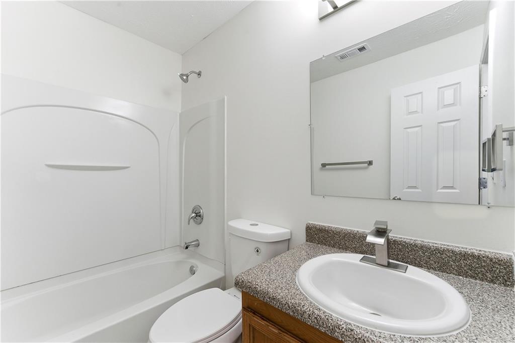 1500 Keystone Drive Conley, GA 30288 - Photo 18 of 25 a bathroom with a granite countertop sink a toilet and shower