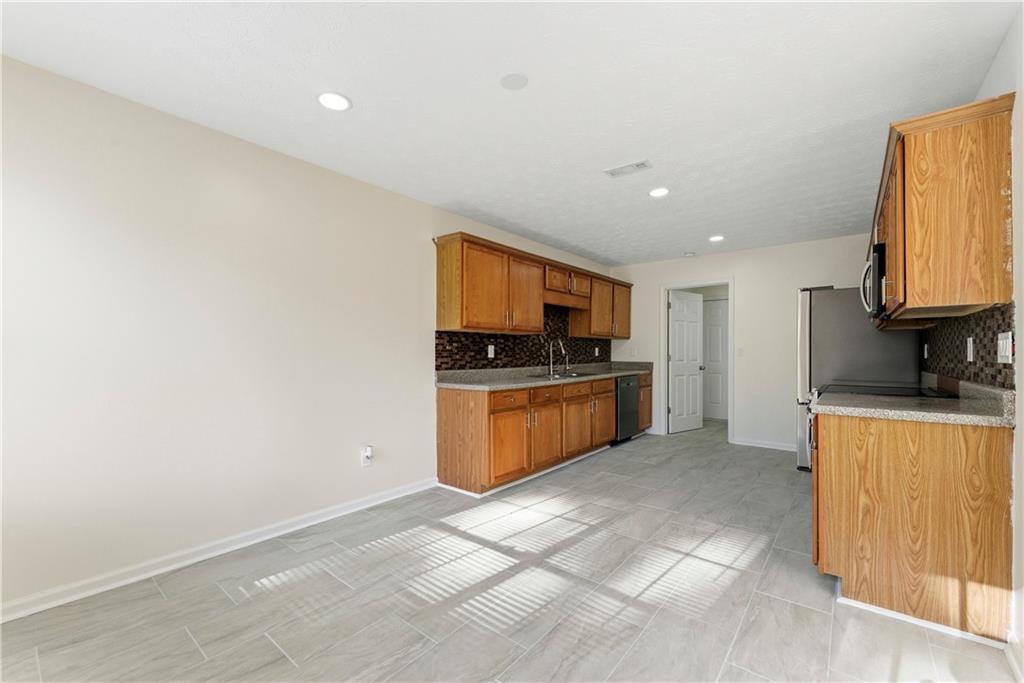 1500 Keystone Drive Conley, GA 30288 - Photo 7 of 25 a kitchen with stainless steel appliances granite countertop a stove a sink and a refrigerator