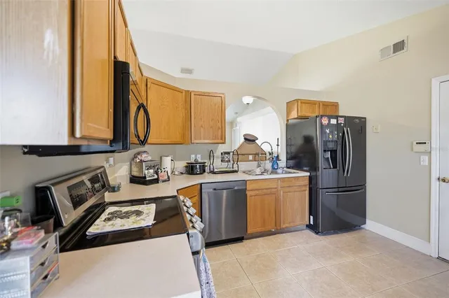 a kitchen with stainless steel appliances granite countertop a refrigerator and a stove