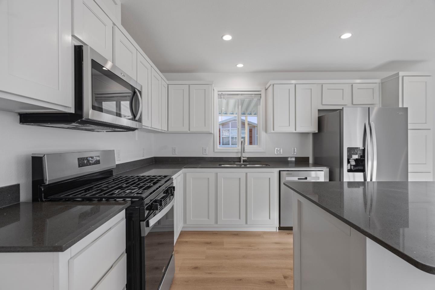 144 Holm Road, Unit 120 Watsonville, CA 95076 - Photo 12 of 25 a kitchen with stainless steel appliances granite countertop a stove refrigerator sink and microwave