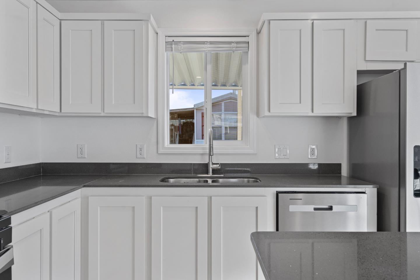 144 Holm Road, Unit 120 Watsonville, CA 95076 - Photo 13 of 25 a kitchen with granite countertop a sink and white cabinets