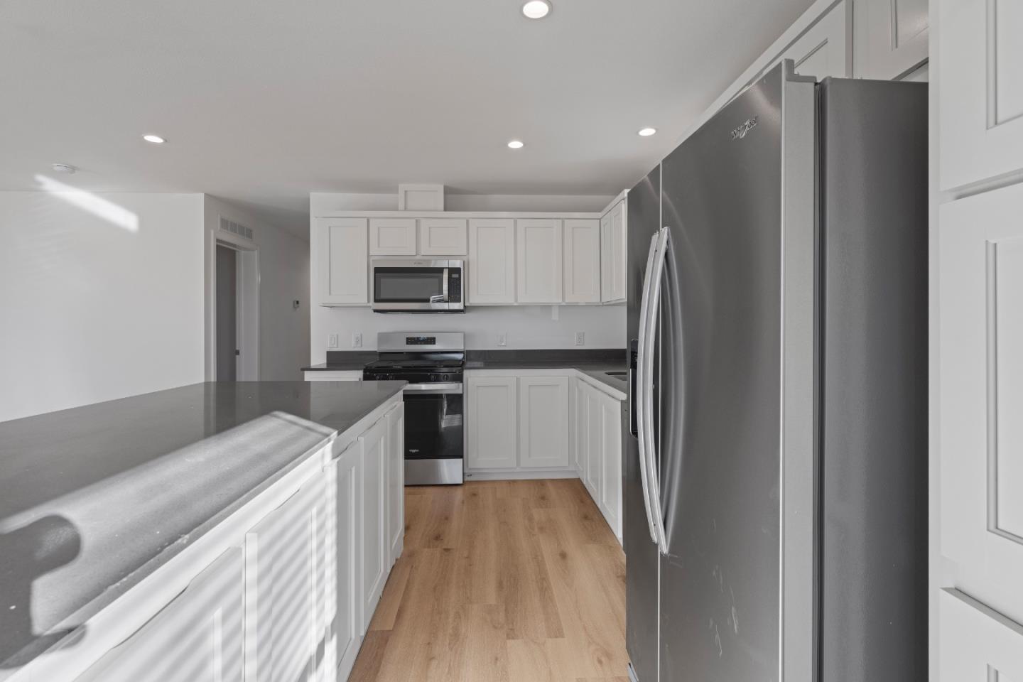 144 Holm Road, Unit 120 Watsonville, CA 95076 - Photo 15 of 25 a kitchen with kitchen island a refrigerator stove and microwave