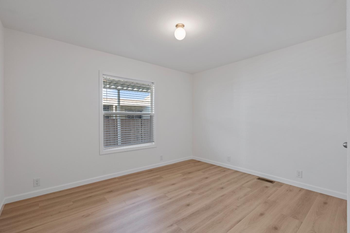 144 Holm Road, Unit 120 Watsonville, CA 95076 - Photo 22 of 25 wooden floor in an empty room with a window