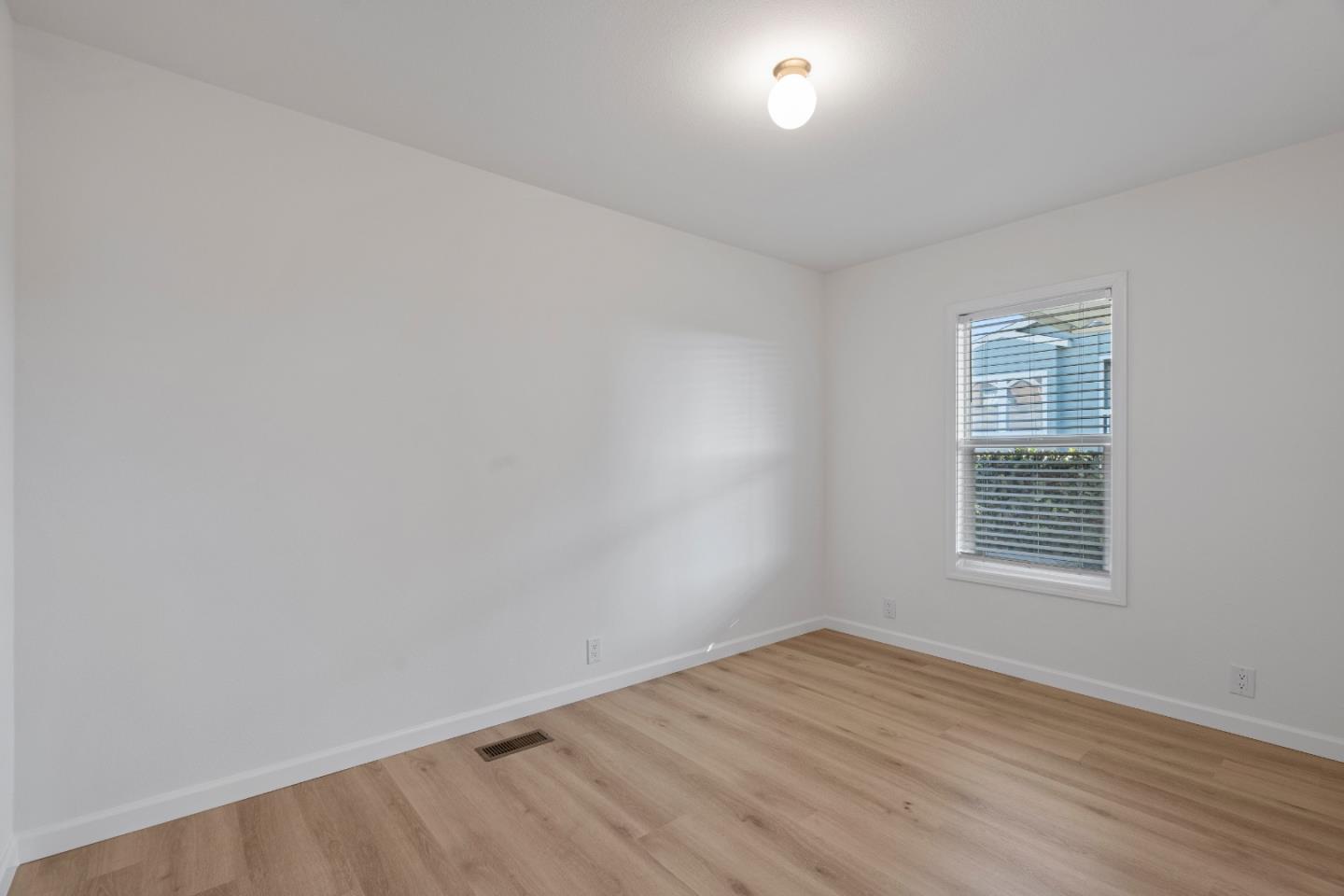 144 Holm Road, Unit 120 Watsonville, CA 95076 - Photo 23 of 25 a view of an empty room with wooden floor and a window