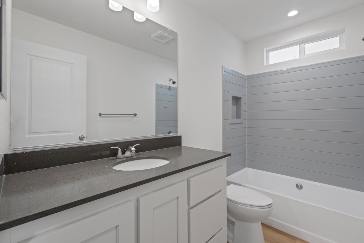 144 Holm Road, Unit 120 Watsonville, CA 95076 - Photo 24 of 25 a bathroom with a granite countertop sink a toilet and shower