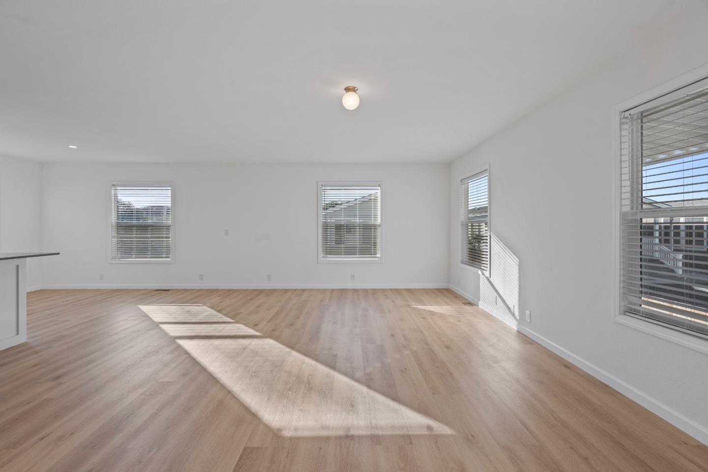 144 Holm Road, Unit 120 Watsonville, CA 95076 - Photo 8 of 25 an empty room with wooden floor and windows