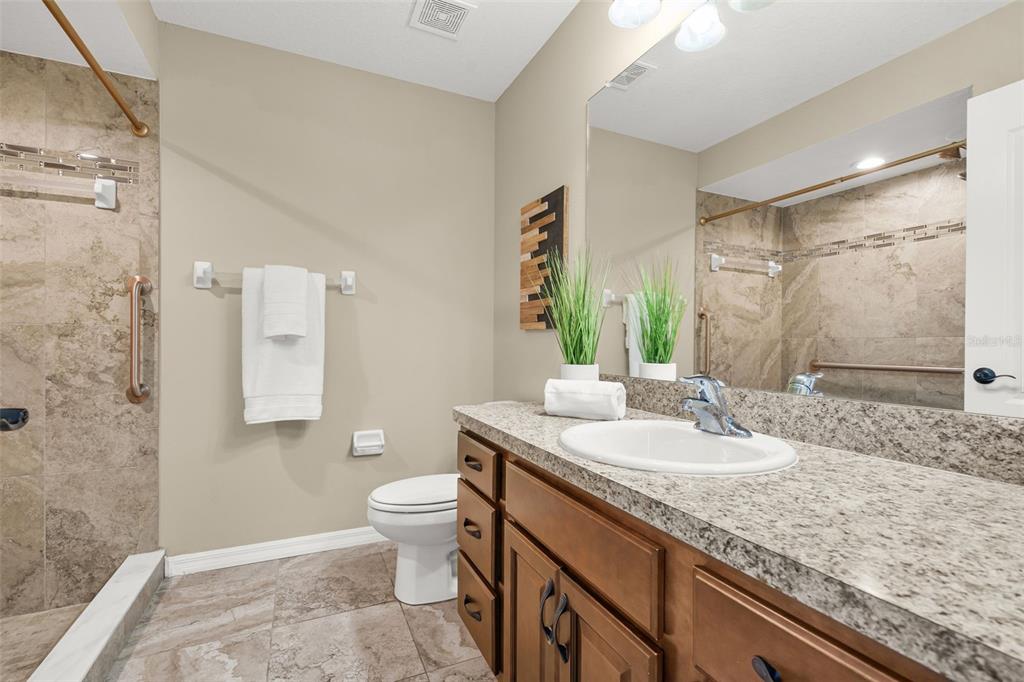 5346 Pierpoint Avenue Spring Hill, FL 34608 - Photo 21 of 41 a bathroom with a granite countertop sink a toilet a mirror and shower