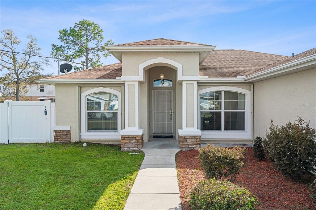 5346 Pierpoint Avenue Spring Hill, FL 34608 - Photo 4 of 41 a front view of a house with a garden