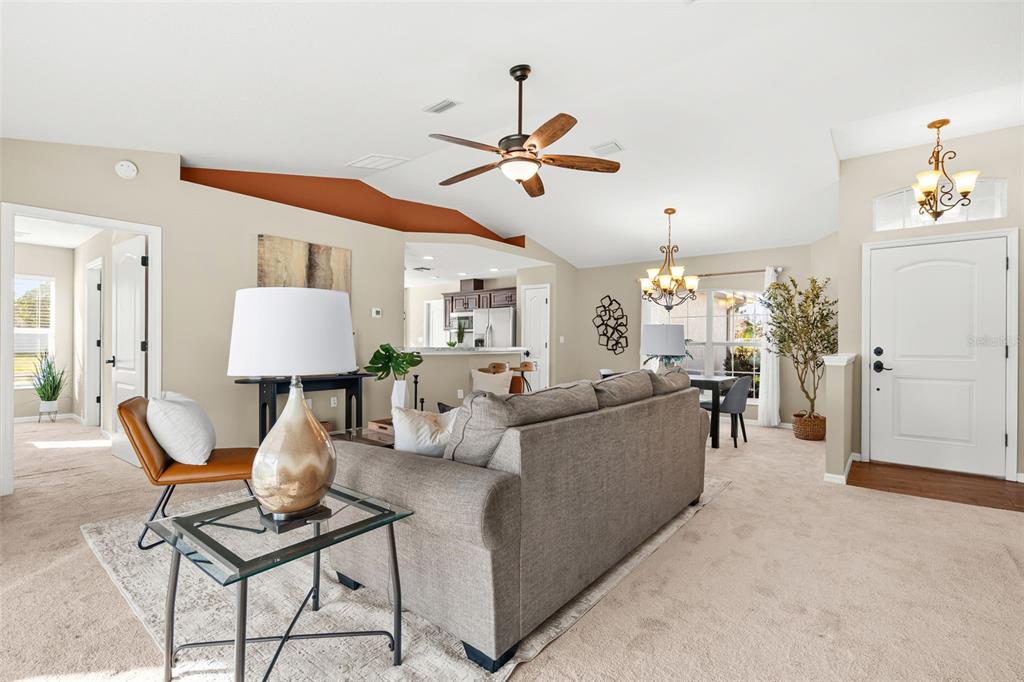 5346 Pierpoint Avenue Spring Hill, FL 34608 - Photo 7 of 41 a living room with furniture a dining table and a chandelier